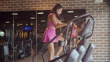 Eine-Frau,-Die-In-Sportkleidung-Auf-Einem-Stepper-Im-Fitnessstudio-Läuft