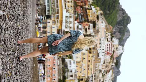 blonde woman tourist on beach of positano, amalfi coast, italy - vertical