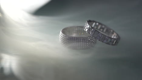 macro shot of wedding rings in smoke - slow motion