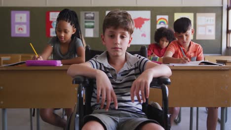 disable boy sitting on his wheelchair in class at school