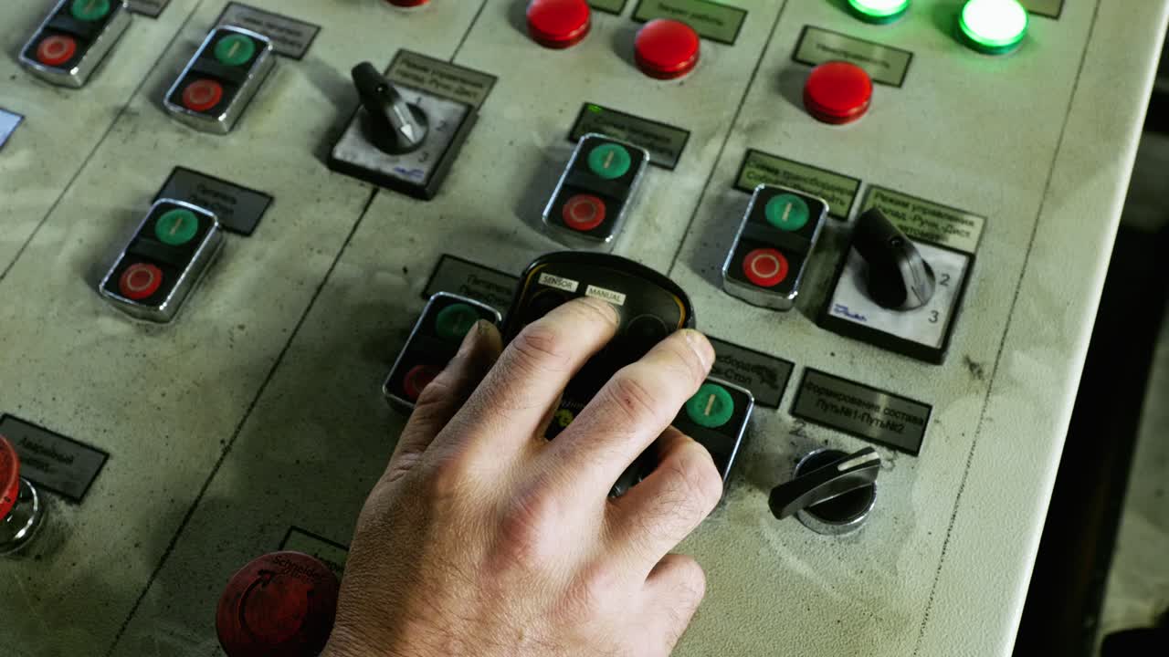 Close up, hand pressing buttons on aged Soviet control panel, European coal port