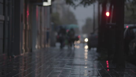a blurred view of a paved street on a rainy evening