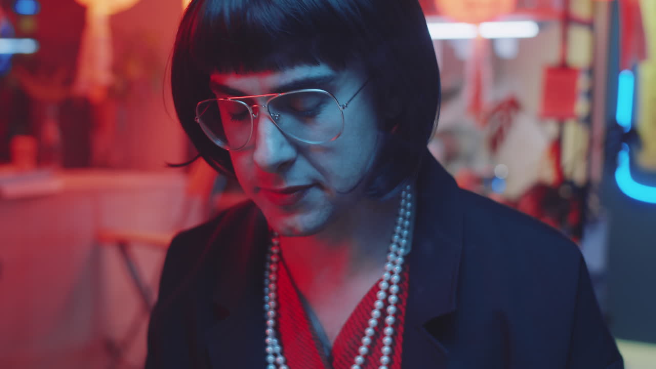 Uomo transgender che si mette il rossetto in un bar