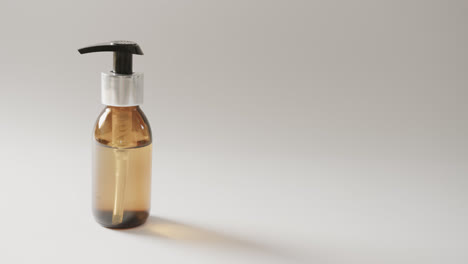 close up of glass bottle with pump with copy space on white background