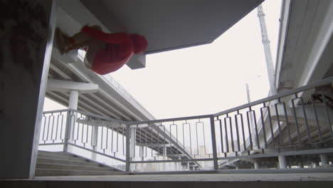 parkourist doing wall backflip on urban staircase