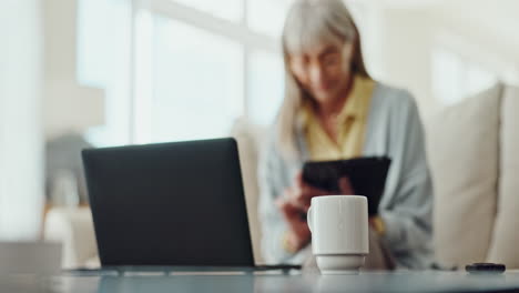 senior woman working from home with laptop and tablet