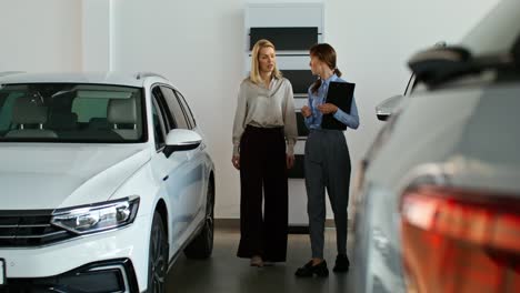 mujer y niña discutiendo la compra de un coche en el concesionario