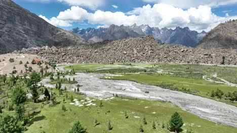 Aerial-drone-rotating-shot-over-Indus-river-flowing-through-Basho-Valley,-surrounded-by-mountain-range-in-Skardu,-Pakistan-on-a-cloudy-day