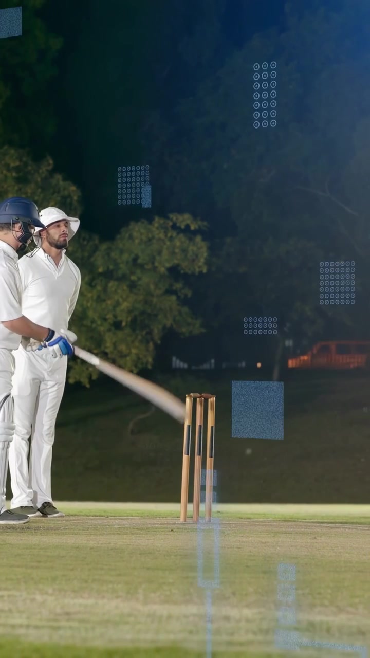 Vertical video: Cricket bowler running up bowling ball taking wicket batsman playing shot at night