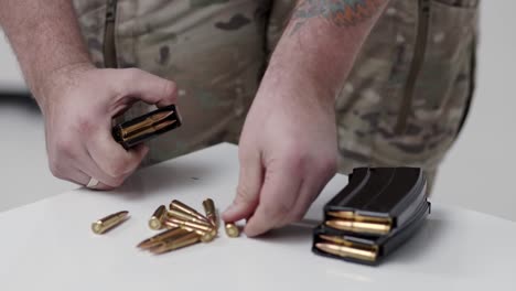 a man close up loading a machine gun clip with ammunition. preparation for shots and war