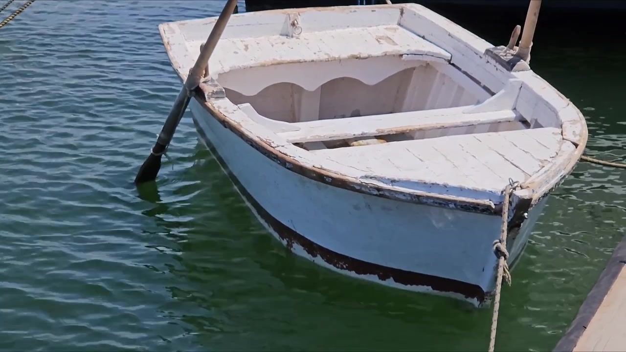 Primo piano di una piccola barca tradizionale in legno che galleggia sulle onde del mare. Texture di increspature calme dell'oceano, peschereccio, dettagli di sfondo marino zen