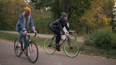 Junges-Hipster-Paar-Genießt-Das-Radfahren-Durch-Den-Park-Auf-Trekkingrädern