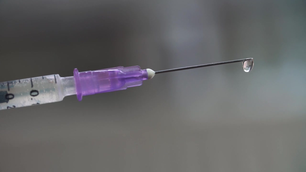 Close-up of Syringe Needle Expelling Liquid Medicine