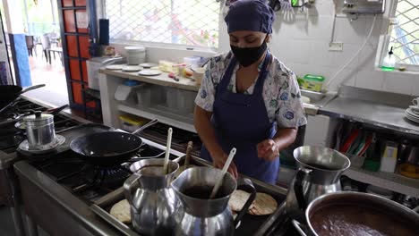 cocinero étnico enfocado cocinando arepas de trigo en la cocina