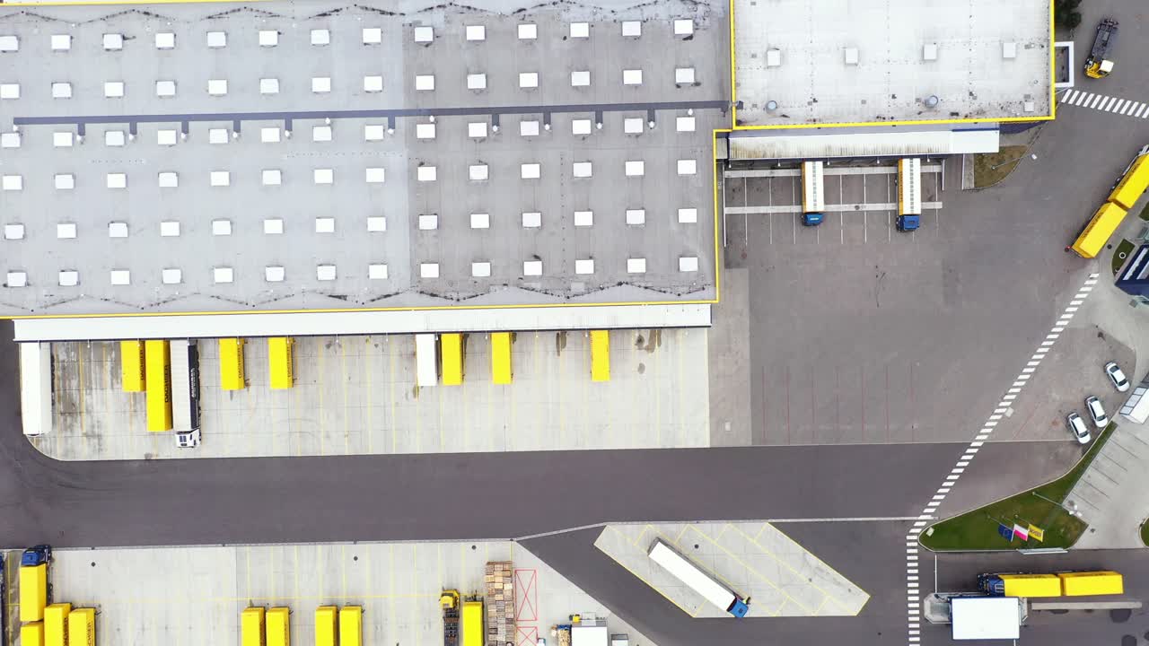 toma aérea del área de carga del edificio de almacenamiento de almacenes industriales donde muchos camiones están cargando y descargando mercancías