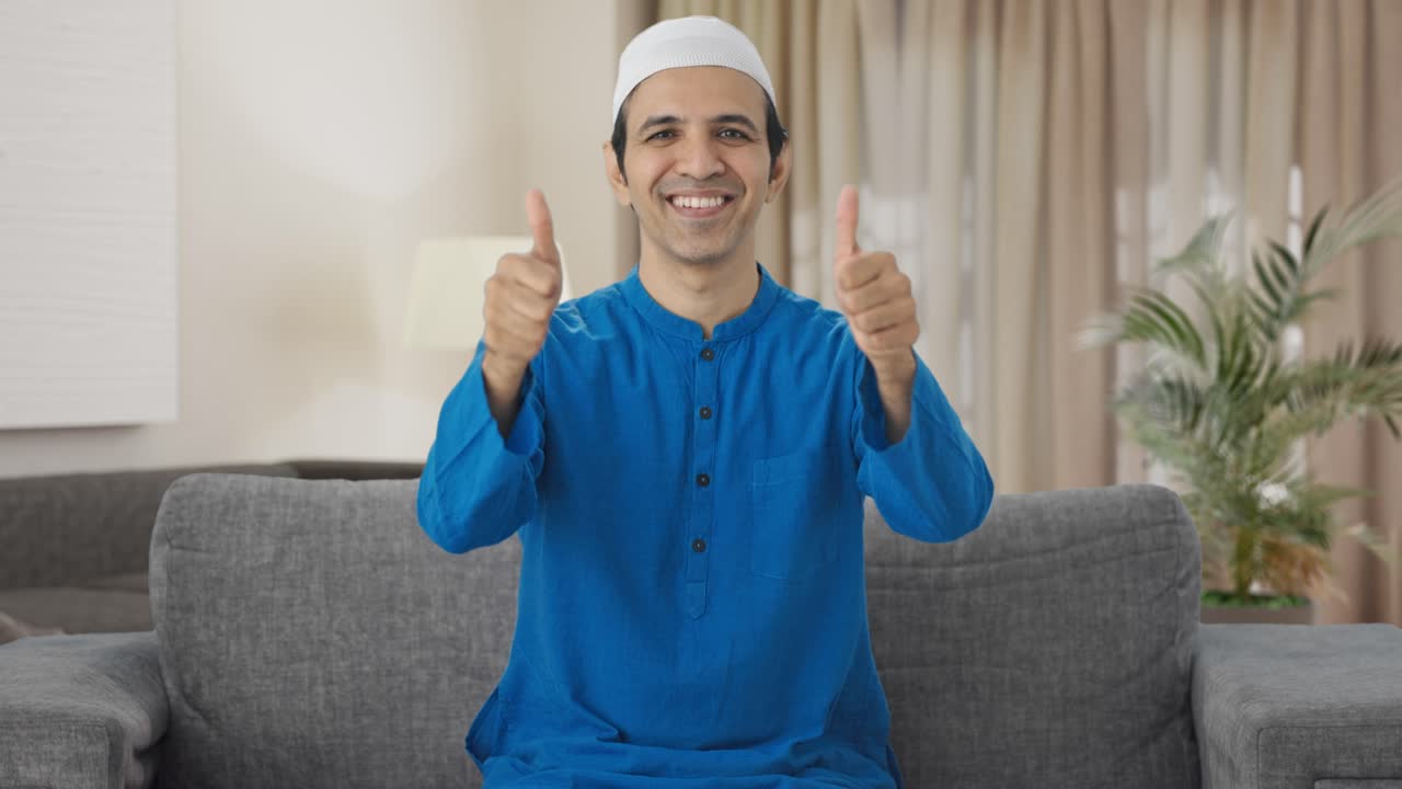 행복한 무슬림 남자가 엄지손가락을 들고