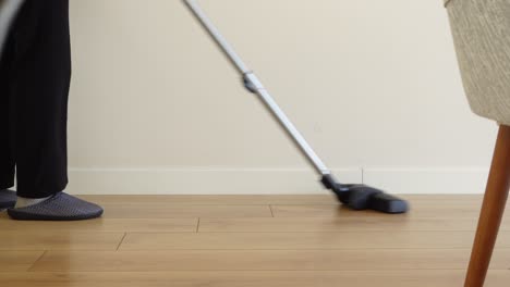 a woman vacuums the floor of a house.