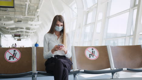 woman wearing mask and using phone in airport