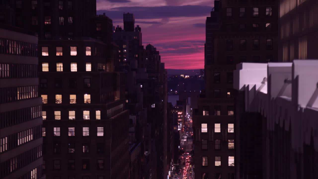 puesta de sol rosa vista asomándose a través de edificios en la ciudad de nueva york