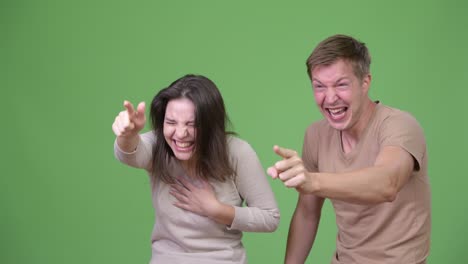 young happy couple laughing and pointing finger together