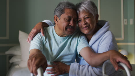 Sonriente-Pareja-De-Raza-Mixta-Senior-Abrazada,-Hombre-Sujetando-Un-Andador