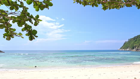 Waves-slowly-come-to-shore-on-a-white-sandy-beach