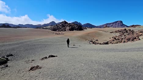 lonely traveler walking on the sandy terrain of roques de garcia, spain