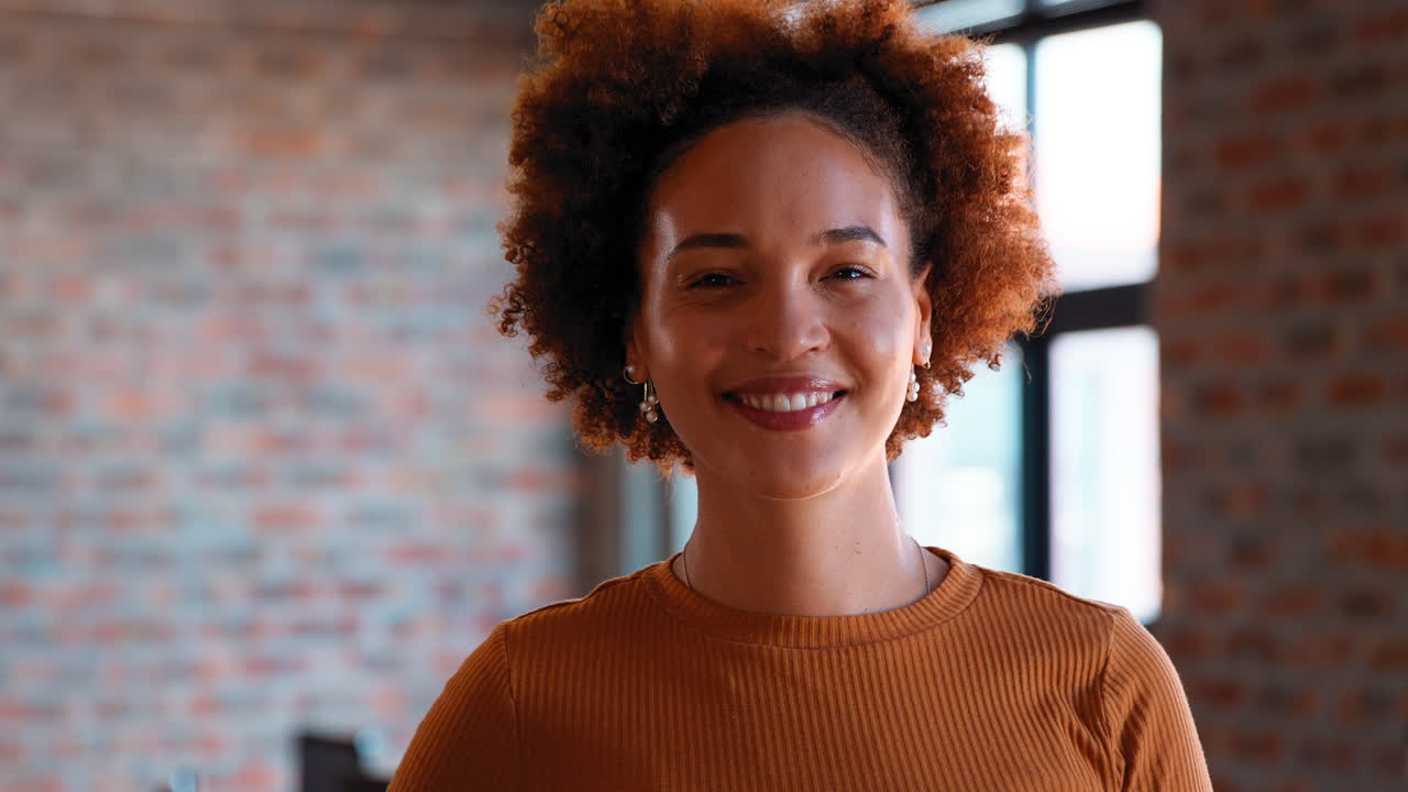 retrato de una mujer de negocios sonriente en la oficina con colegas trabajando en el fondo