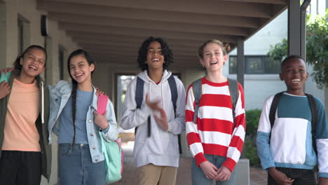 diverse group of multiracial students laughing and walking together at school campus