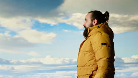 alone traveler stands on a mountain summit soaking in the stunning view of peaks