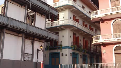 Historic-buildings-with-hispanic-architecture-revealing-cobblestone-street-corner-with-light-traffic-during-a-sunny-summer-morning-in-Panama-City's-Casco-Viejo