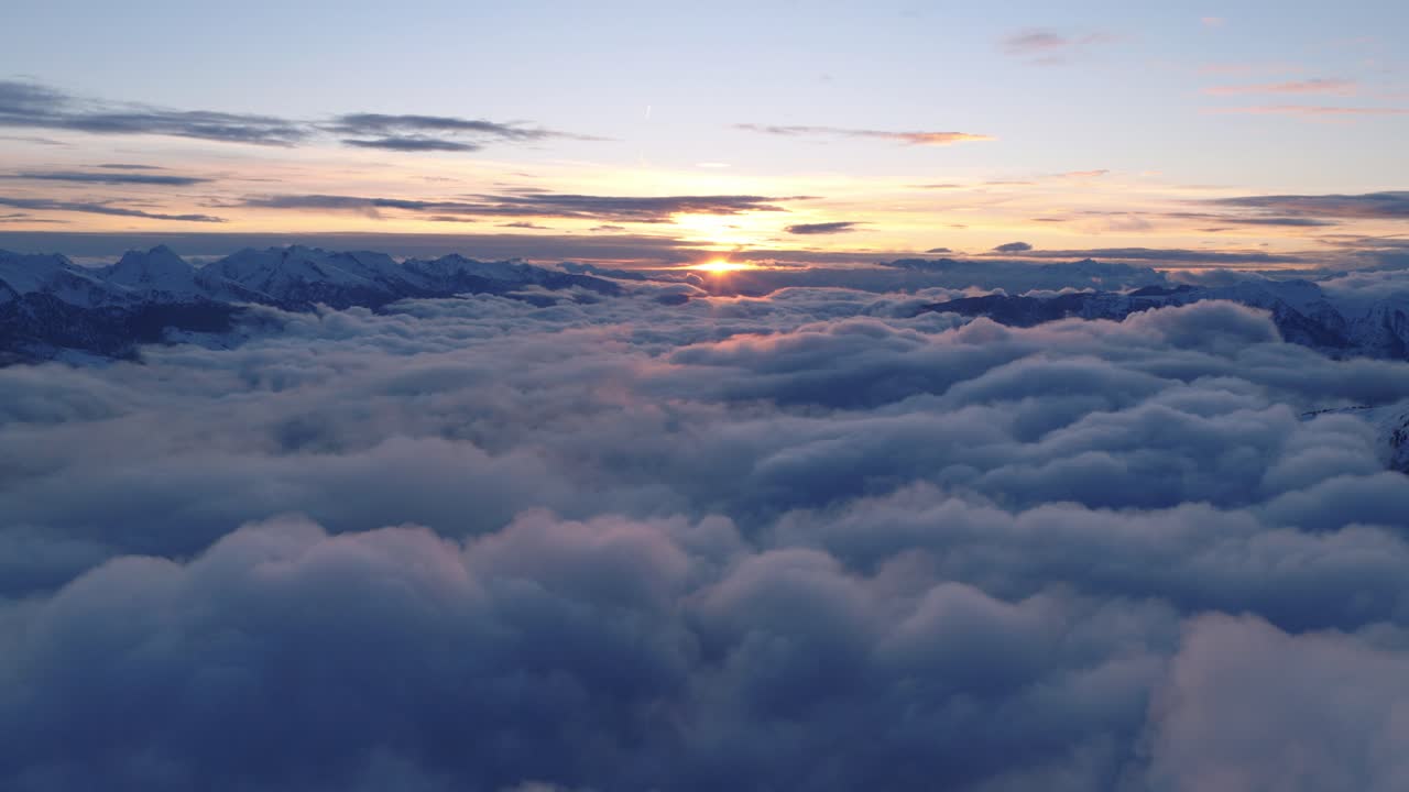 Tramonto mozzafiato su un mare di nuvole, con cime montuose innevate nella Catena del Lagorai, Val di Fiemme, Italia. - ripresa aerea.