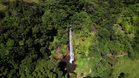 Drone-flying-backwards-revealing-impressive-Viento-Fresco-Waterfall-in-Monteverde-rainforest