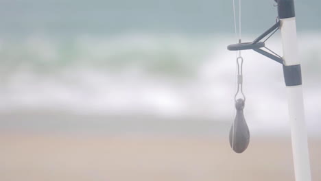 해변 해안선의 낚싯대에 무게가 걸려 있습니다.