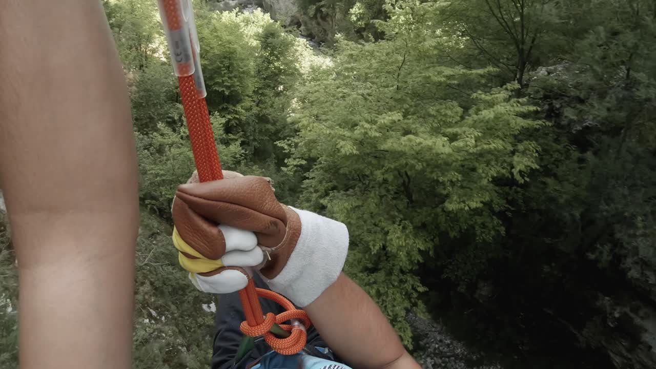 punto de vista de un hombre haciendo slackline en una montaña atravesando árboles