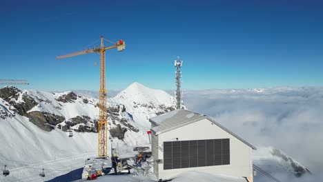 y la grúa de la torre cerca de la nevada suiza al borde de la estación de montaña