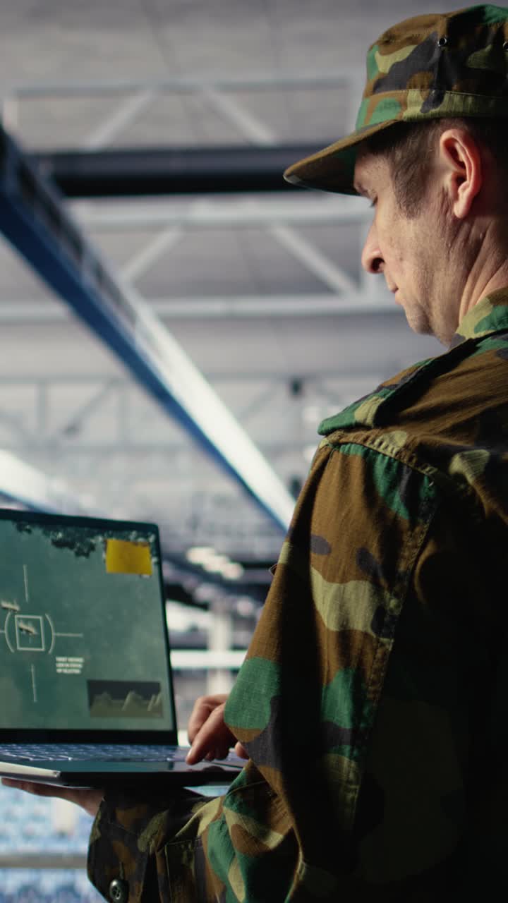 Højformatvideo af militærtekniker i et datacenter, der sporer satellitkoordinater ved hjælp af en notebook