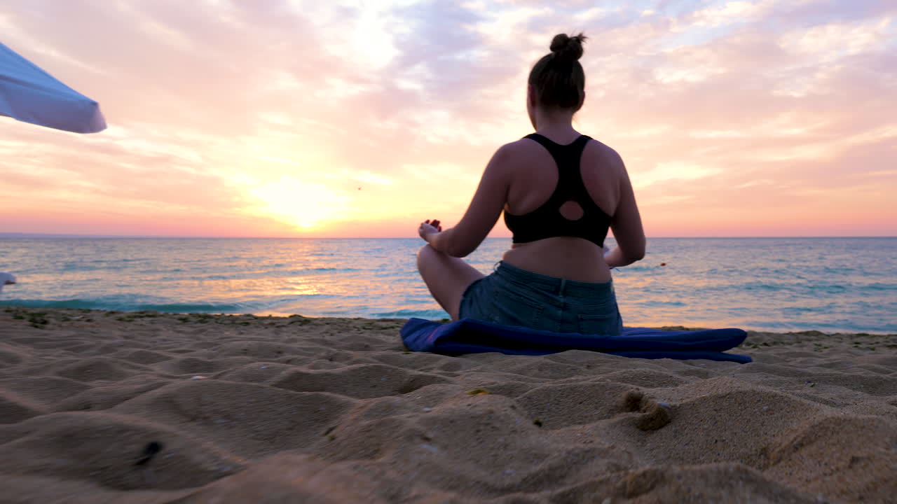 Peace and relaxation while woman is doing yoga on the beach