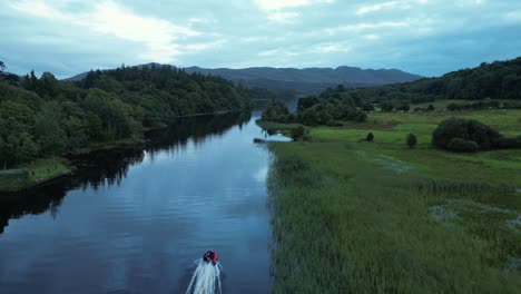 a speedboat cruising up the river surrounded by nature dusk aerial