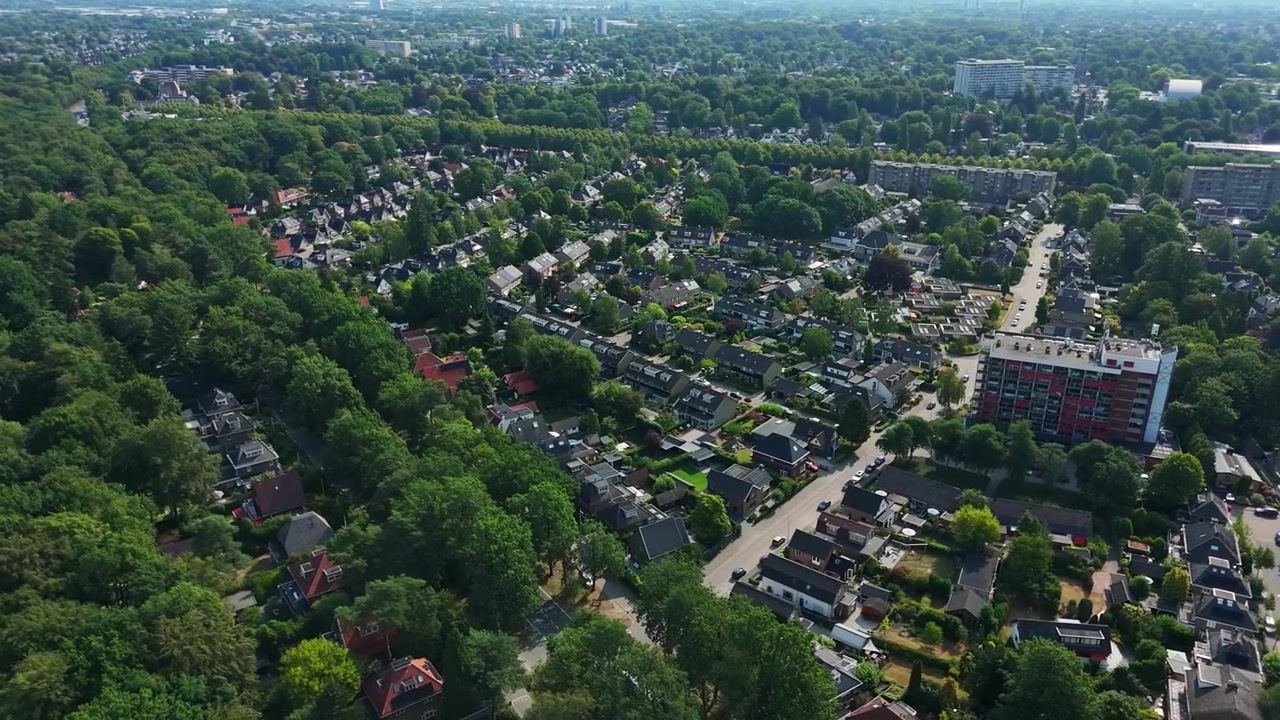 Vista aerea di una zona residenziale verdeggiante ad Apeldoorn, Paesi Bassi, con case, condomini, margini di foresta, strade e pianificazione urbana verde