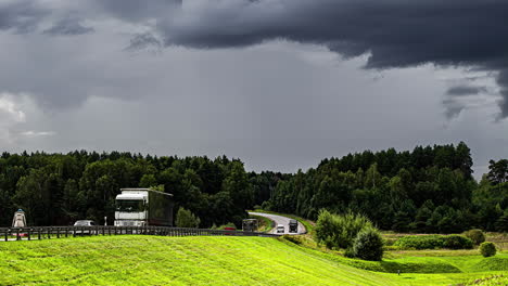 Zeitrafferaufnahme-Einer-Dunklen-Wolkenbewegung-über-Der-Verkehrsbewegung-über-Der-Autobahn,-Umgeben-Von-Grünen-Wiesen-Und-Bäumen-An-Einem-Bewölkten-Tag