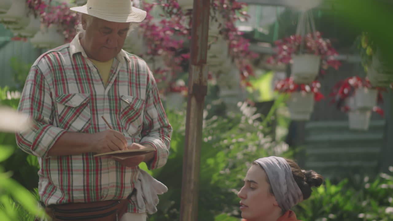 Nurseryman Doing Inventory of Plants with Female Coworker