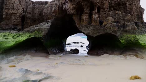 Túnel-De-Cueva-De-Islote-De-Roca-De-Geología-Natural-Causado-Por-La-Erosión-Del-Mar-En-Una-Playa-De-Arena-En-La-Isla-De-Porto-Santo-En-Portugal,-Toma-Estática-HD-De-50-Fps