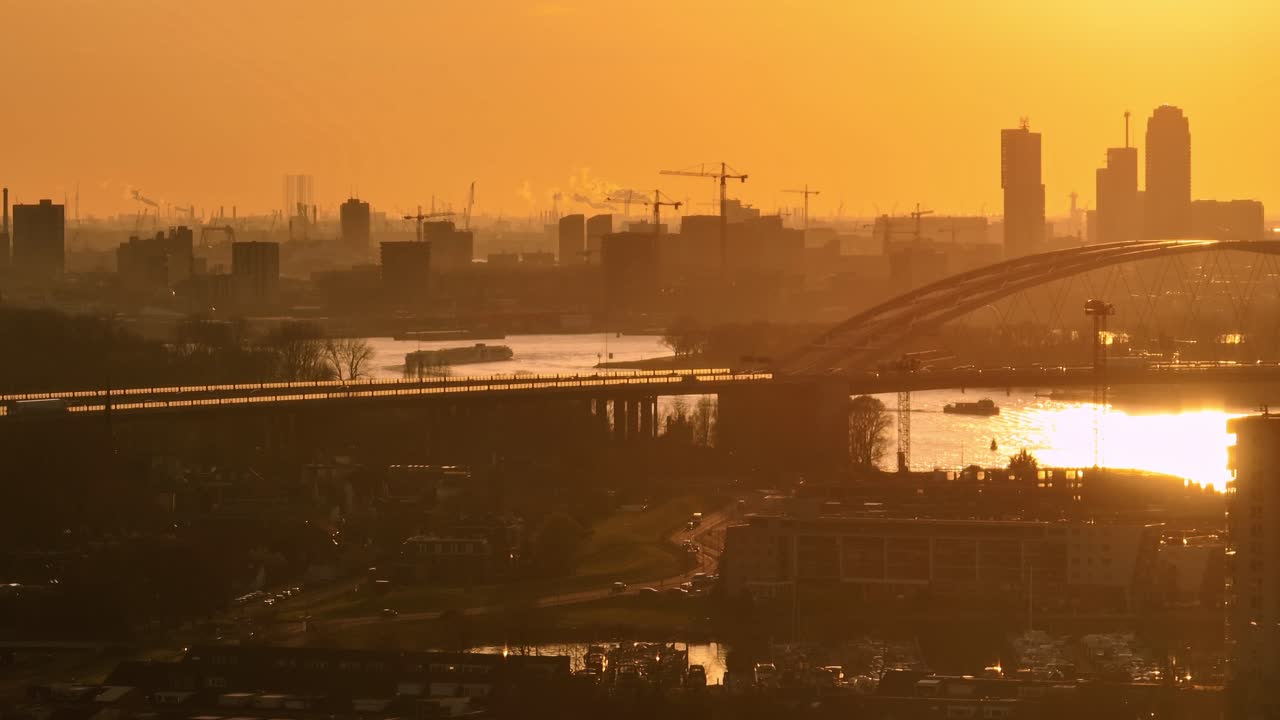 건설과 강을 가진 네덜란드 도시 위의 일몰