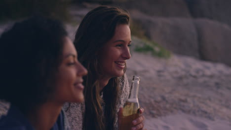 Beach-bonfire-with-group-of-friends,-drinking-beer-and-playing-guitar