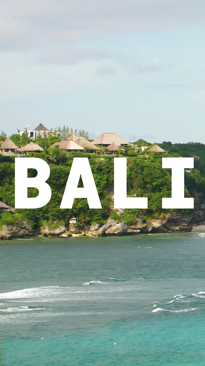 Vertical Video Of Tropical Sea And Coastline Scene Overlaid With Animated Graphic Spelling Out Bali