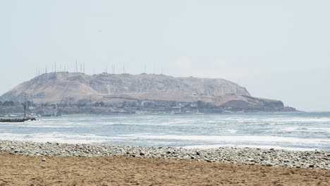 Sunny-day,-Morro-solar-and-the-ocean-waves-coming-into-bay---Timelapse