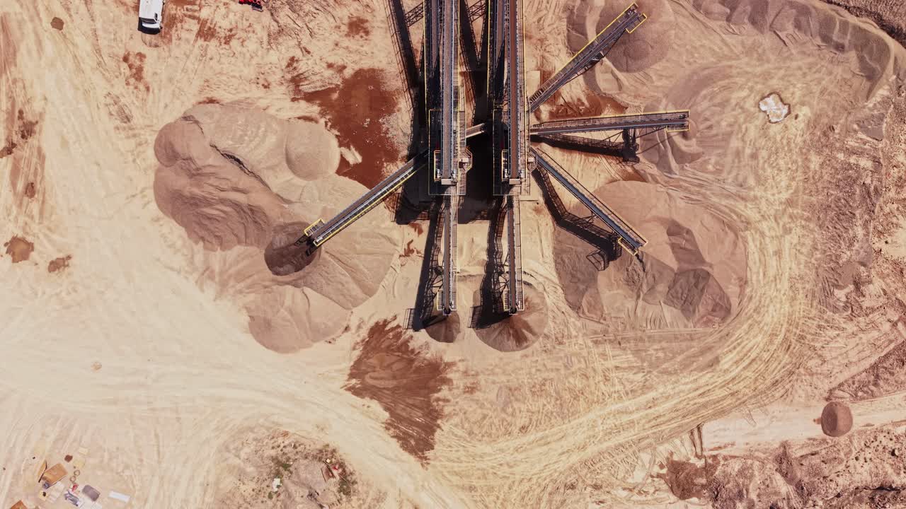 Heavy machinery moves materials in a large industrial site during the day