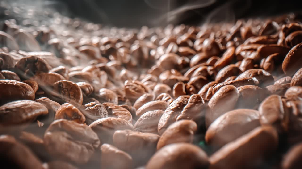 Close up of seeds of coffee. Fragrant coffee beans are roasted smoke comes from coffee beans.