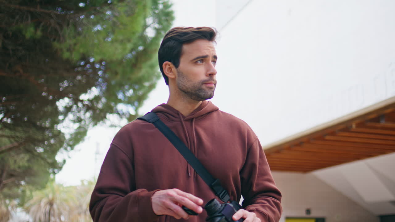 Handsome sportsman drinking bottle after training outdoors. guy walking